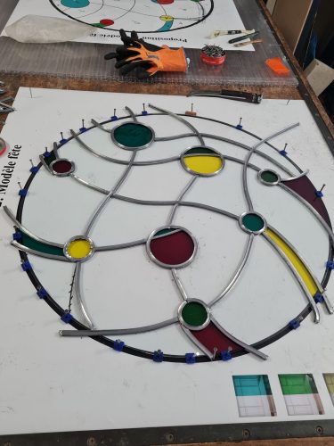 Montage d'un panneau de vitrail contemporain en verres soufflés.